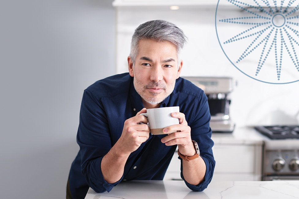 man in kitchen with cup of espresso